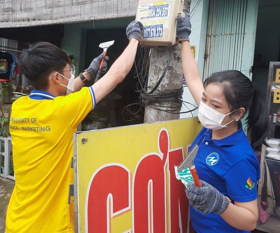 Vào sáng chủ nhật hàng tuần, sinh viên Trường ĐH Tài chính-Marketing bóc gỡ quảng cáo tín dụng đen nơi công cộng.